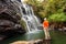 Trekker looks at wild waterfall