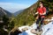 Trekker resting on a snowy mountain path in a wonderful sunny day.