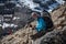 Trekker rests on stone in Khumbu valley on a way to Everest Base