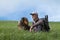 Trekker sitting on top of the hill with his dog