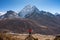 A trekker standing on rock and looking to Ama Dablam mountain peak in Dingboche village, Everest base camp trekking route, Nepal