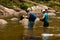 Trekkers cross river in Sinharaya rain forest Park, Sri Lanka