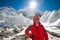 Trekkes is posing at camera in front of huge glacier falling fro