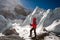 Trekkes is posing at camera in front of huge glacier falling fro