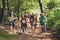 Trekking, camping and wild life concept. Four best friends are hiking in the spring woods, the guy is checking the route on a map,