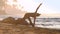Tremendous girl silhouette stretches doing yoga on sand