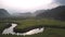 Tremendous meandering river surrounded by green fields