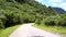 Tremendous winding highland road near trees under cloudy sky