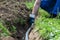 In a trench the workerâ€™s hand lays the water pipe