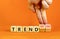 Trend or trendwatching symbol. Concept words Trend and trendwatching on wooden cubes. Businessman hand. Beautiful orange table