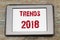 Trends 2018 inscription on e-book screen on wooden table