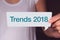 Trends 2018 wording on white talk bubble with hand.