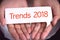 Trends 2018 wording on white talk bubble with hand.