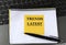 TRENDS LATEST - words on a yellow piece of paper on the background of a laptop with a notebook and a pen