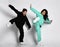 Trendy active interracial sportive boy and girl jumping with high kick leg portrait