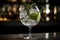 A trendy, artisanal gin and tonic, served in a large, balloon glass with a variety of botanical garnishes, such as cucumber,
