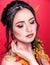 Trendy autumnal makeup . Fashion beauty model girl. Closeup portrait isolated on red background