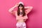 Trendy beautiful long haired young model with black rounded glasses, rose street clothes posing on pink background. Charming