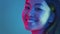 Trendy beauty. Young positive asian woman turning face to camera and smiling, bright neon lights, empty space