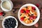 Trendy breakfast pancake cereal with berries, above view table scene over wood