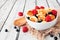 Trendy breakfast pancake cereal with berries, side view close up against white wood