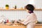 Trendy businesswoman placing dishes with pastry on bar counter in cafeteria.