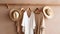 Trendy capsule wardrobe in beige and white on a hanger with straw hats.