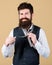 For a trendy casual look. Hipster with long beard and moustache dressing in classic style. Bearded hipster tying a