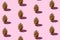 Trendy Christmas pattern made with golden pine cones on pink background