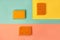 Trendy collage made of orange color sponges on yellow, pink coral and trendy mint green blue background.