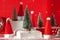 Trendy composition Christmas trees and Santa Hat on podium on red background. New Year concept