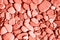 Trendy coral colour background from sea pebbles