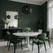 Trendy dining room in calm green color Empty plain walls and emerald velor chairs Black accents and white marble Large table