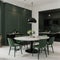 Trendy dining room in calm green color Empty plain walls and emerald velor chairs Black accents and white marble Large table