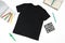 Trendy fashion T-shirt black styled basic clothes and accessories collection on white background. Flat lay, top view. Chess, book