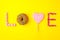 Trendy flat lay lettering. Inscription love by sweets jn yellow background