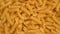 Trendy flat view closeup rolling yellow macaroni. Top view, flat lay. Nature concept. Texture background, pattern.