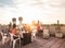 Trendy friends having barbecue party on top of the roof - Happy people doing bbq dinner outdoor - Main focus on woman with yellow