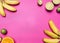 Trendy fruit set on a bright pink background, mini bananas, limes, oranges,lined frame, space for text, top view