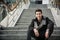 Trendy handsome young man sitting on a long staircase outside