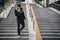 Trendy handsome young man in winter fashion standing on a long staircase