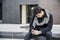 Trendy handsome young man in winter fashion using cell phone sitting