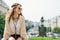 Trendy hippie woman tourist relaxing on stone parapet in Prague