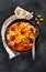 Trendy hybrid food. Mac and cheese pizza on dark background