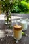 Trendy Korean dalgona coffee in a glass served in a garden on a spring day