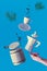 Trendy levitation. Flying line of coffee beans between ceramic coffee maker and espresso cup with saucer. Blue mint background