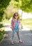 Trendy little girl in park with teddybear in hand