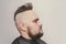 trendy man portrait. Punk styled man with Mohawk hairstyle on gray background