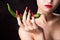 Trendy manicure and red lips with green chili pepper.