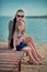 Trendy mother with black hairs and red lips in sun glasses enjoy summer time on a beach with her baby daughter ,Adorable scene of